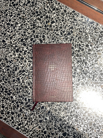 Brown leather notebook on a black and white speckled surface