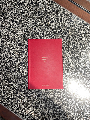 Red book with white text on a black and white speckled surface